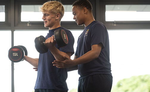 Two students lifting weights