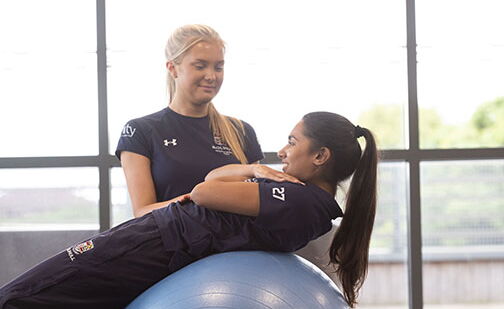 Two students using an exercise ball